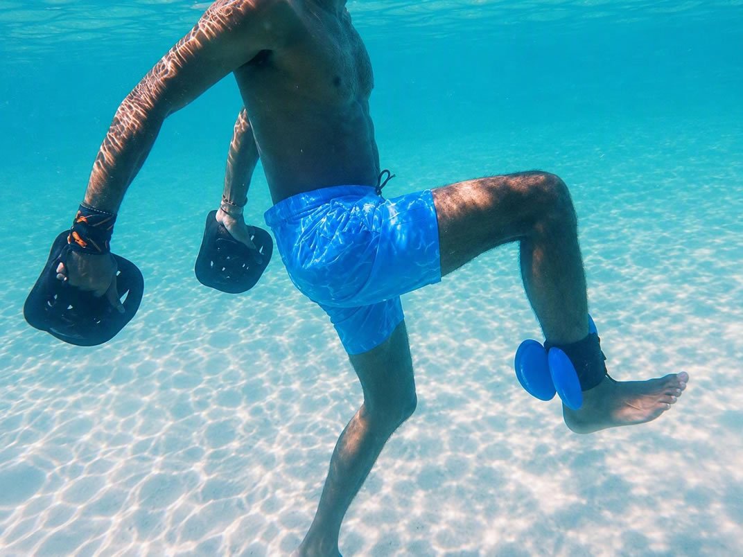 One-on-one underwater ocean session showing full-body movement with aquatic resistance equipment