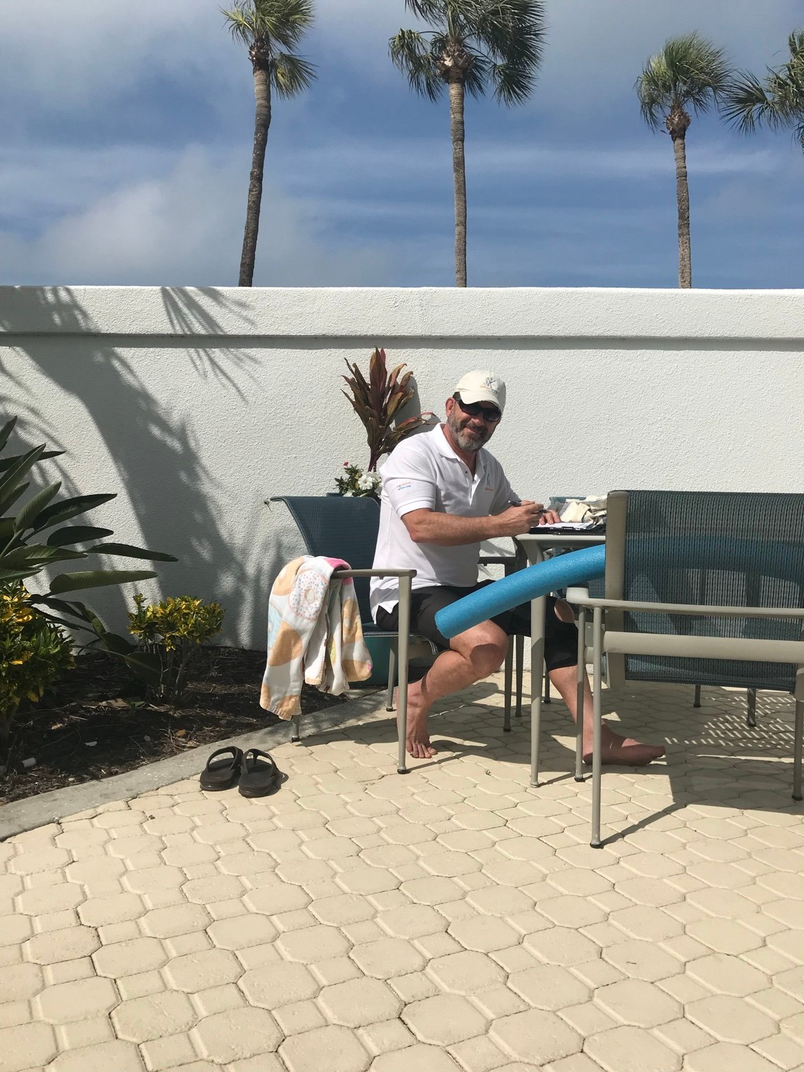 Stuart Davidson seated poolside beneath a dramatic sky.