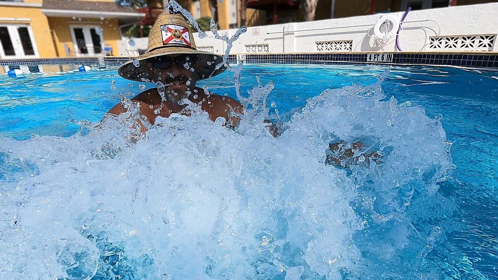 AquaFit Sports founder in a straw hat as white water erupts in front of him during oscillatory training