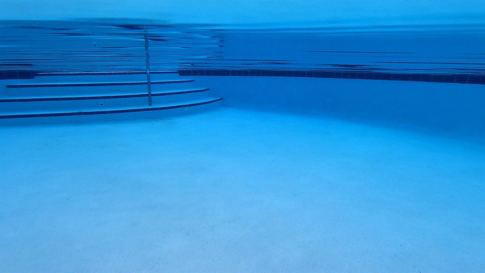 Sunlight rippling across the floor of an empty pool